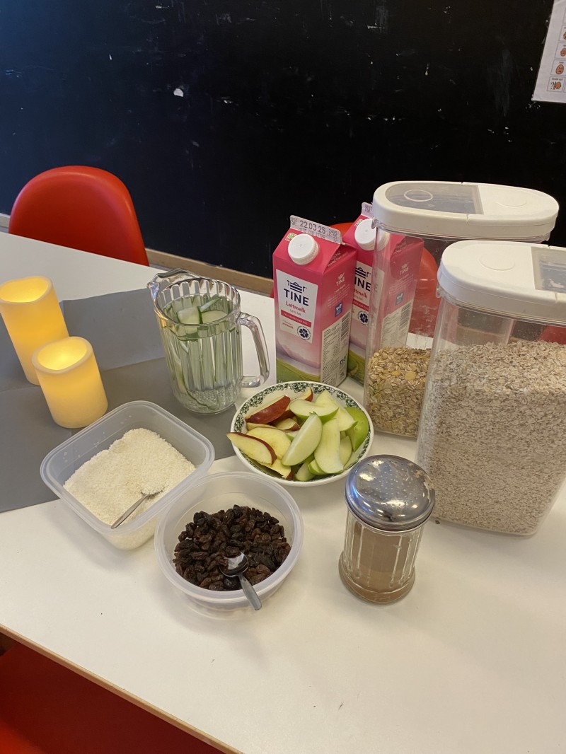 Havregryn med melk, rosiner, kokos, kanel og vann med epler til frokosten
